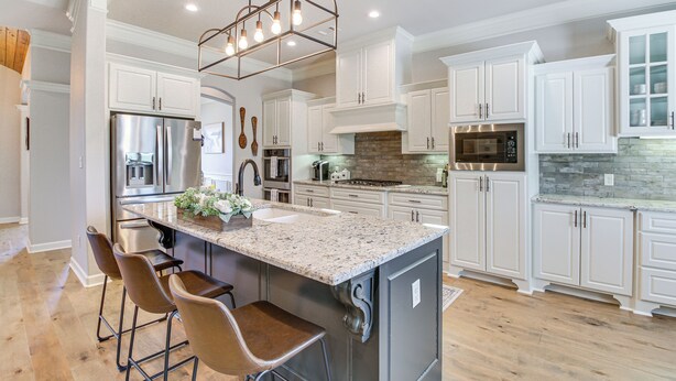 A modern kitchen with white cabinets, stainless steel appliances, and a granite island with bar stools. - Spacious Hot Springs Village Home < 1 Mi to Lake! (Hot Springs Village)