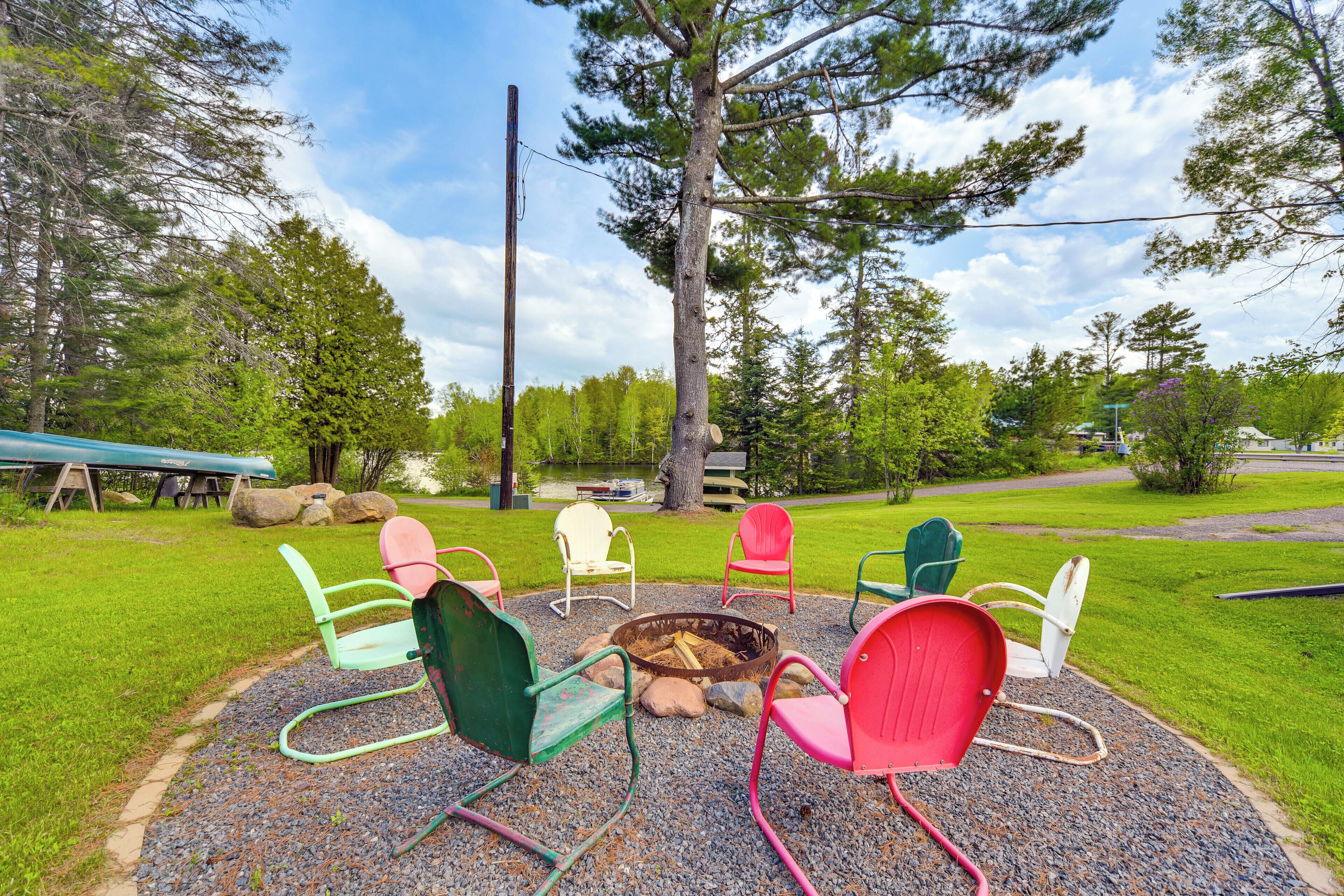 A circular seating arrangement around a fire pit with a gravel path leading to it.