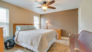A bedroom with a bed, nightstand, lamp, and a wooden bench. - Angola Getaway: Walk to Lake Erie Beach Park! (Angola)