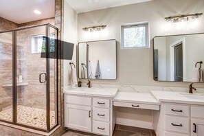 A modern bathroom with a glass shower enclosure, two sinks, and a large mirror. - Game Room + Pool Access: Spacious Cabin in Arnold (Arnold)
