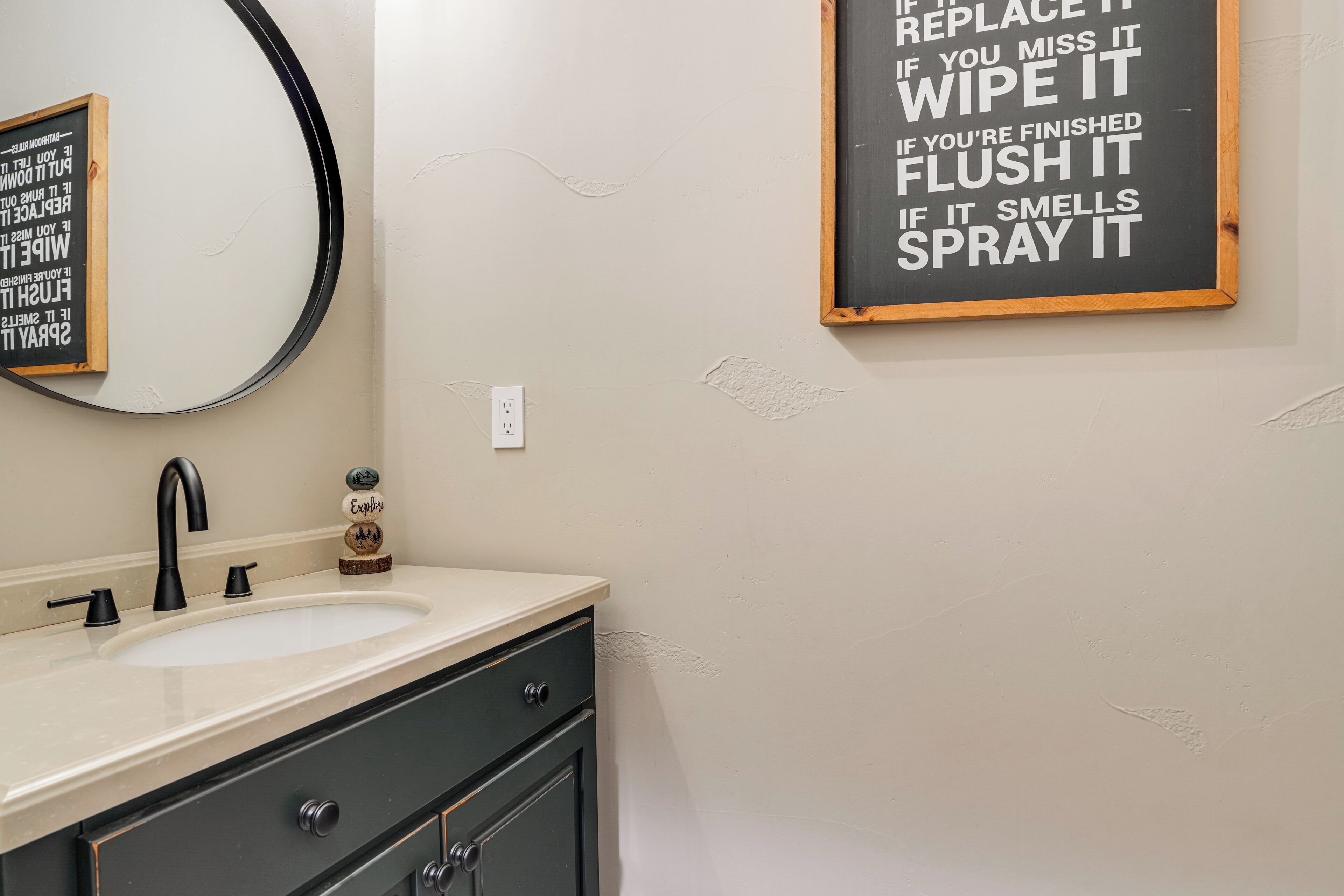 A bathroom with a sink, mirror, and a wall-mounted sign with cleaning instructions.