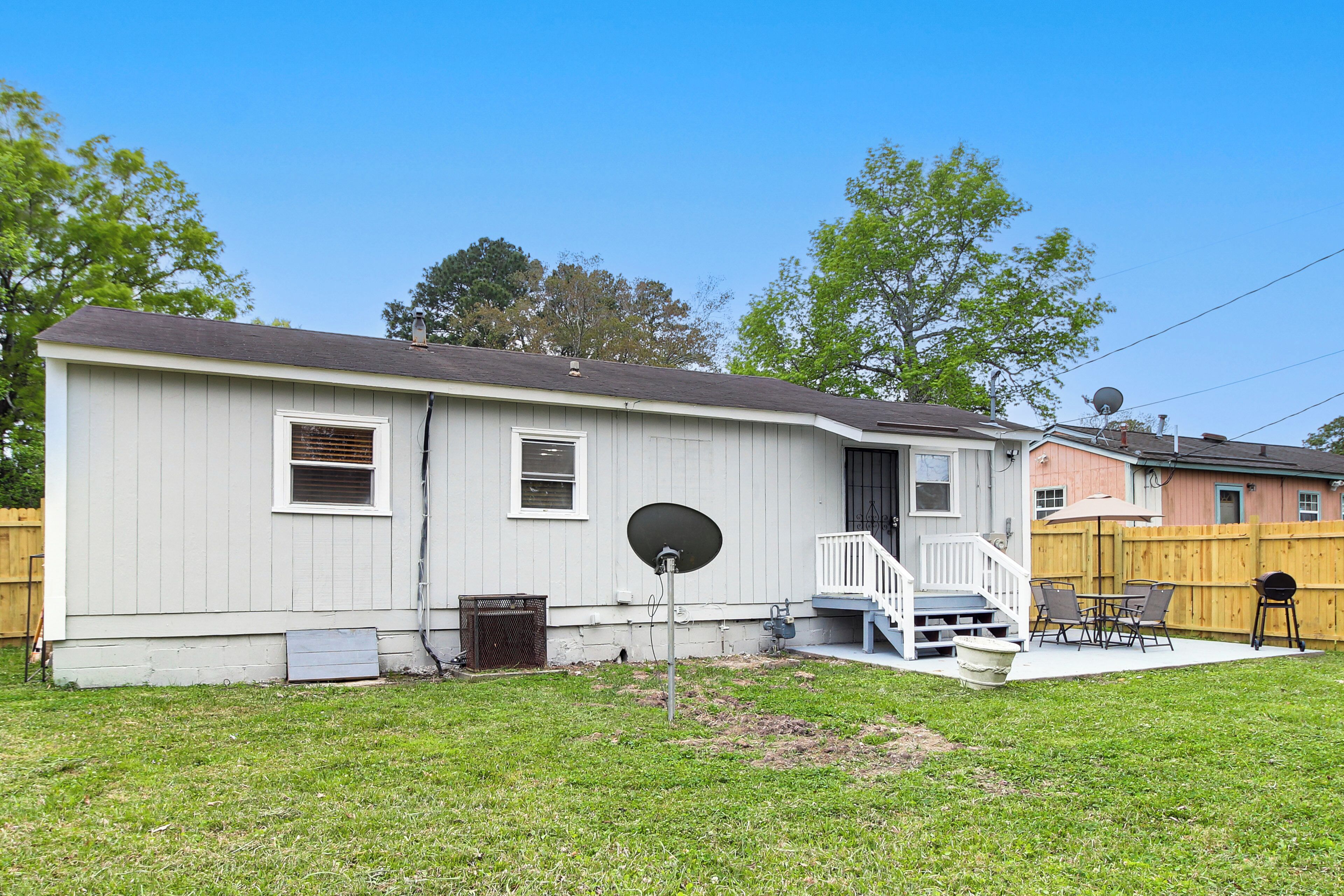 A single-story house with a small front yard, a satellite dish, and a wooden deck.