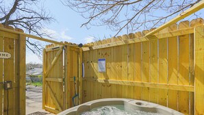 A wooden gate with a sign that reads "Welcome," leading to a hot tub area. - Jefferson City Bungalow: Hot Tub & Patio! (Jefferson City)
