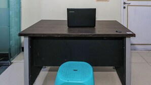 A desk with a Lenovo laptop and a blue stool in front. - Hotel O Budi Residence 2 (Bekasi)