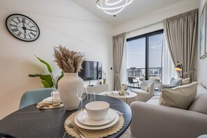 Enjoy a meal at the large round dining table, surrounded by a comfortable sofa and city views.