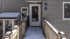 A snow-covered walkway leading to a house with a front door and two side doors, each marked with a house number. - Mountain Oasis fo
Cozy & Peaceful View - Walk 2 All Seasons Resort - Fireplace (Sugar Mountain)