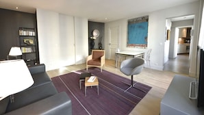 Un salon moderne comprenant un canapé, une table basse et un coin repas avec une table et des chaises.