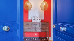 A hallway with a red wall, a wooden bench, and two hanging lamps. - Soubise, 1BR/1BA, 4 people (París)