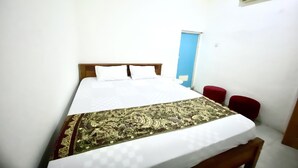 Una camera da letto con un letto, una sedia rossa e una porta blu.