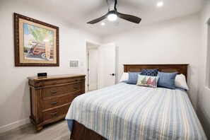 A bedroom with a bed, dresser, ceiling fan, and a framed picture on the wall. - 122 36th St A | Gorgeous + Modern Oasis w/ Huge Front Patio (Newport Beach)