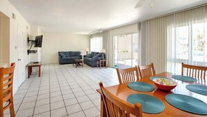 Un espacio habitable amplio con una mesa de comedor, dos sofás y un ventilador de techo.