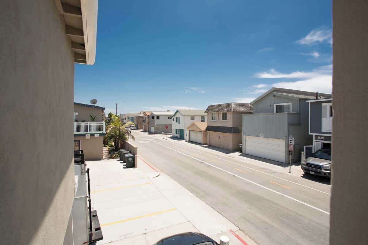 A residential street with houses, a clear sky, and a parked car.