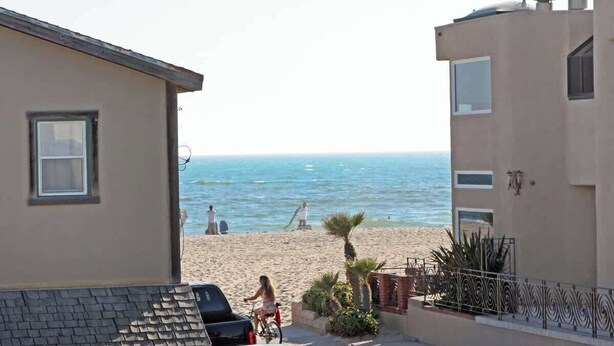 A coastal residential area with a beach in the background. - 3612 Seashore | 4BR Ocean Escape | Steps from the Beach (Newport Beach)