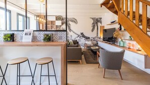 A modern kitchen with a wooden island, bar stools, and pendant lighting. - Coastal paradise – House with sea view in Loguivy (Ploubazlanec)