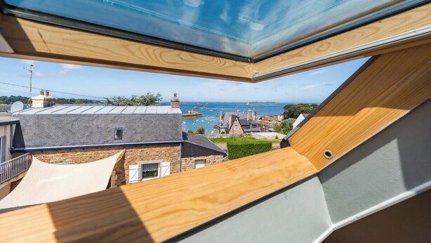 A modern house with a large skylight, a view of the sea, and a sloped roof. - Coastal paradise – House with sea view in Loguivy (Ploubazlanec)