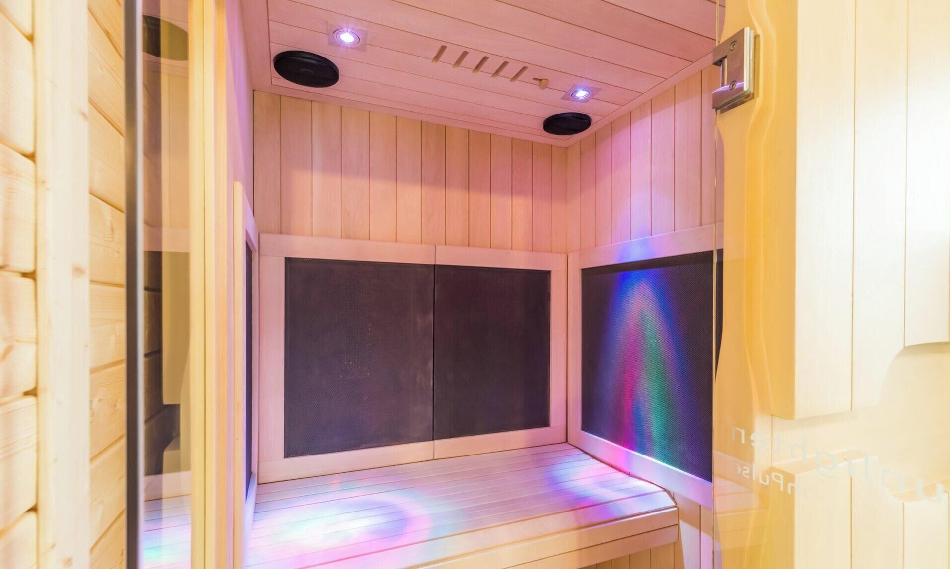 A sauna with wooden walls and a bench.