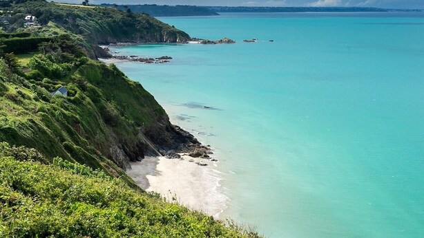 A coastal landscape with a beach, cliffs, and a house on the hillside. - Exceptional apartment - close to the sea (Saint-Brieuc)
