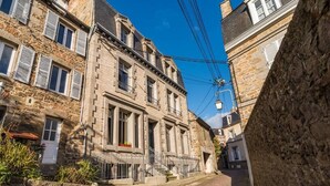A narrow cobblestone street flanked by historic stone buildings with multiple windows and shutters. - Exceptional apartment - close to the sea (Saint-Brieuc)