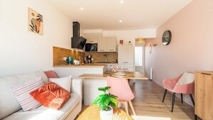 Een modern appartement met een woonkamer, eetgedeelte en keuken.