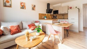 Een moderne woonkamer met een bank, salontafel en een eethoek met een stoel en tafel.