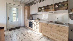 Eine moderne Küche mit Kochinsel, Einbaugeräten und einem großen Fenster.