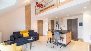 Eine moderne Wohnung mit Wohnzimmer, Essbereich und Küchenzeile.