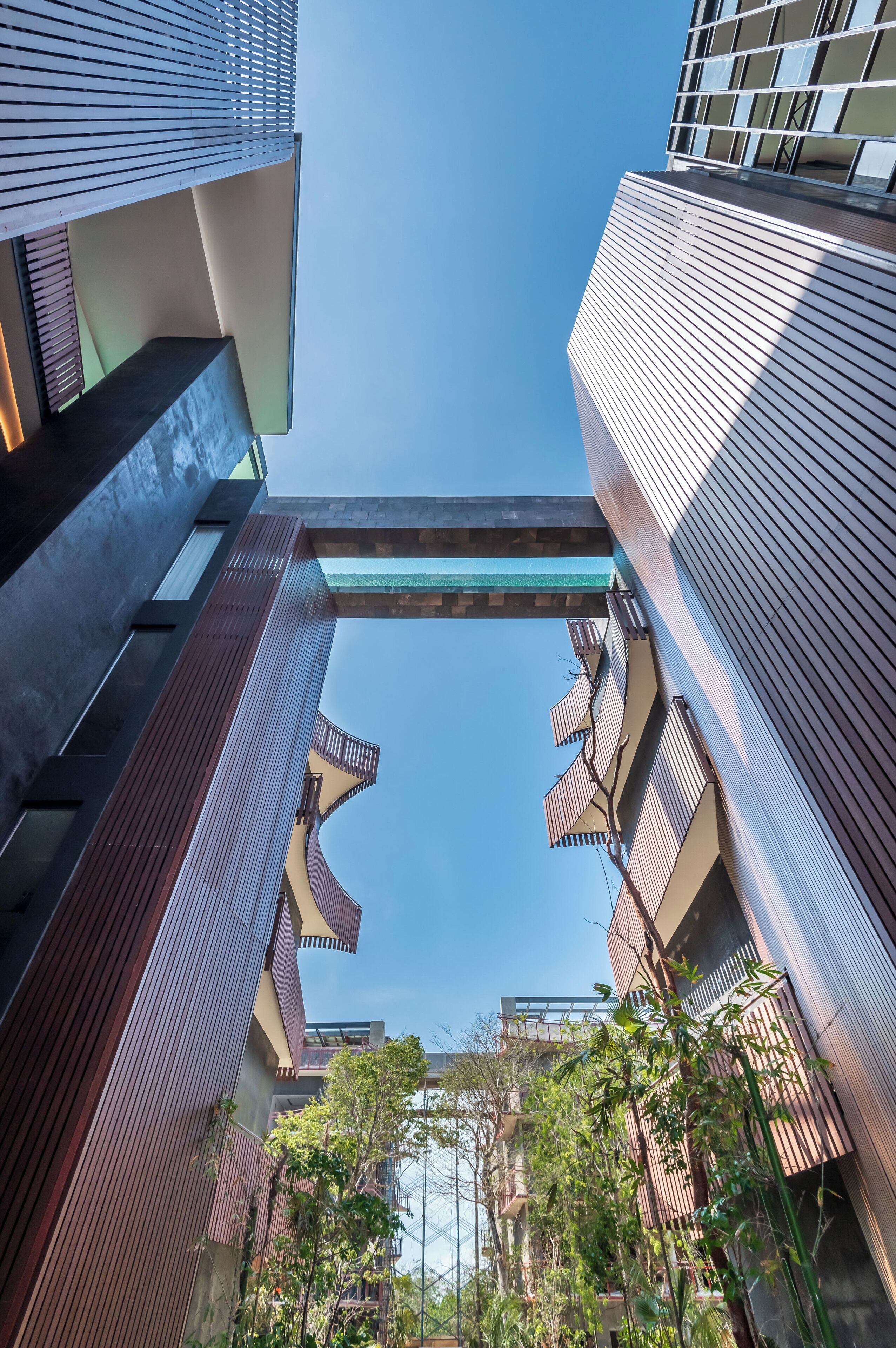 A modern building with a unique architectural design, featuring a central atrium and multiple balconies.