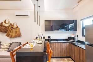 A modern kitchen with a central island, wooden cabinets, and a built-in oven. - Casa Lucho, Live The Good Life! (Tulum)