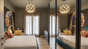 A hotel room with a large mirror, two beds, a dresser, and a vanity with a mirror. - Carignano Luxury Suite by Wonderful Italy (Genova)
