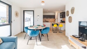 Un appartement moderne comprenant un coin repas, une cuisine et un salon.