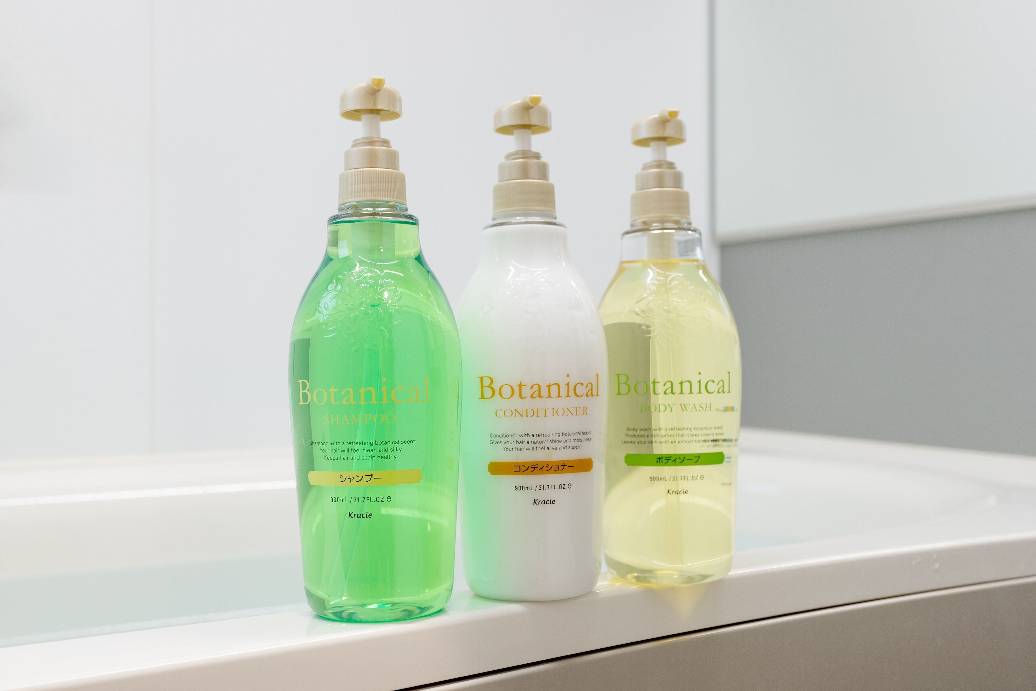 Three bottles of Botanical body wash on a white shelf.
