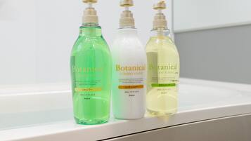 Three bottles of Botanical body wash on a white shelf.