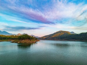 A serene lake surrounded by forested hills and mountains. - Botanik Gol Evleri (Bucak)