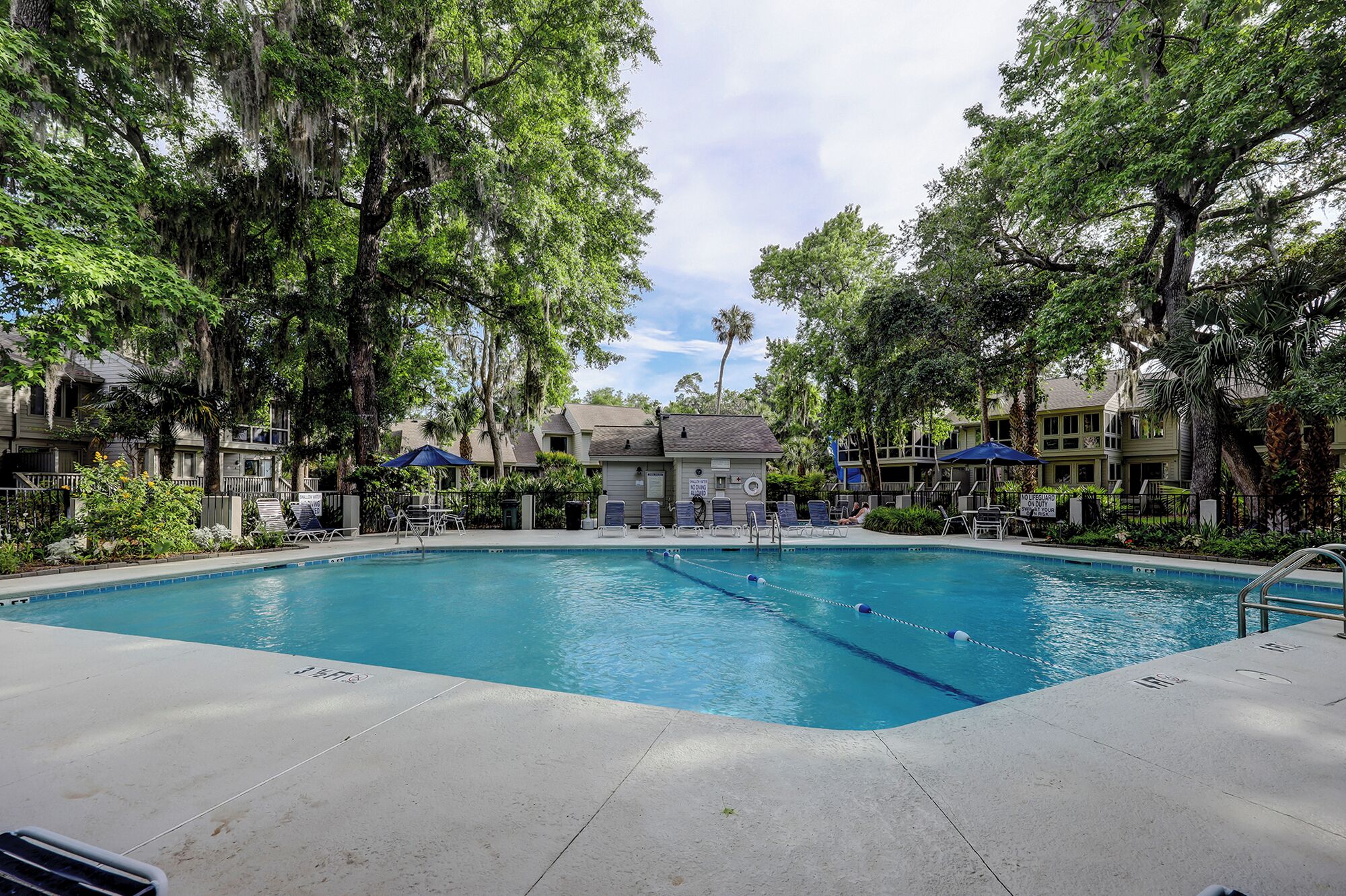A swimming pool surrounded by trees and buildings.