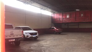 Un espace de stationnement doté d’un sol en béton et d’un toit en métal.