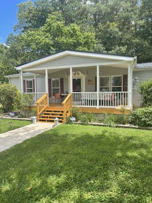 A single-story house with a front porch, a staircase leading to the entrance, and a well-maintained lawn.