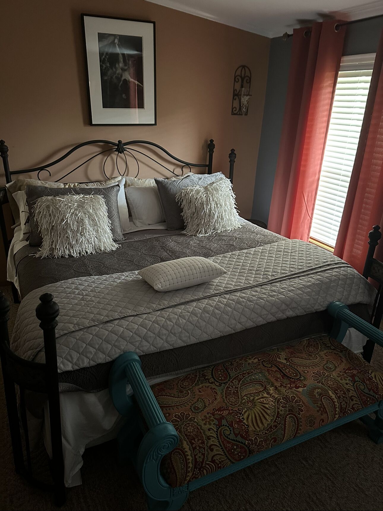 A bed with a quilted mattress, multiple pillows, and a headboard.