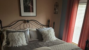 A bed with a quilted mattress, multiple pillows, and a headboard. - The  “MERMAIDS LAIR” (Rehoboth Beach)