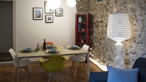 A dining area with a table set for four, surrounded by chairs, a red cabinet, and framed pictures on the wall. - House Garden San Lorenzo (Salerno)