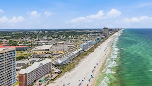 A coastal cityscape with a beachfront, high-rise buildings, and a clear sky.