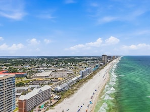 A coastal cityscape with a beachfront, high-rise buildings, and a clear sky.