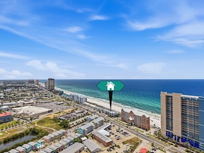 Panorama costiero con un hotel in evidenza, spiaggia e edifici urbani.