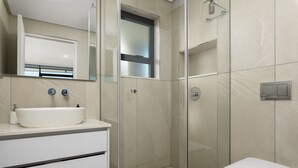 Ein modernes Badezimmer mit Waschbecken, Duschkabine aus Glas und Toilette.