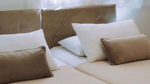 Ett hotellrum med två sängar, var och en med en sänggavel och flera kuddar.