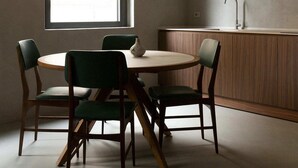 Ein schlichter Essbereich mit einem runden Tisch, vier Stühlen, einem Fenster und einer integrierten Küche mit Spüle.