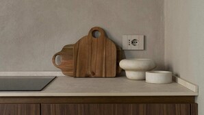 Eine Küchenarbeitsplatte mit einem Holztisch, einer weißen Schüssel und einem kleinen Behälter.