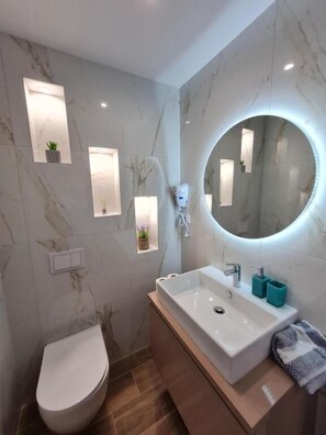 Deluxe Double Room with side sea view | Badezimmer | Kostenlose Toilettenartikel, Haartrockner, Hausschuhe