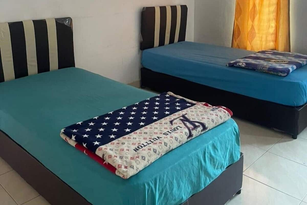 Una habitación con dos camas, cada una con un edredón de diferente color.