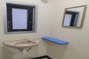 Ein Badezimmer mit Waschbecken, Spiegel und Fenster.