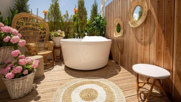 A wooden deck with a hot tub, wicker furniture, and woven mats. - Foga Hebrus  (Ksamil)